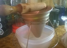 This is an image of a cone shaped colander and a wooden mallet 